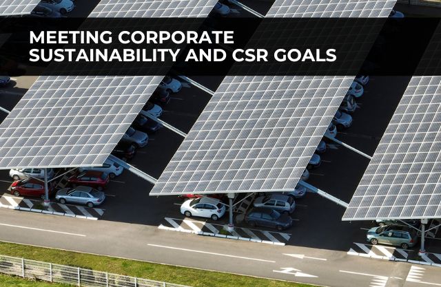 Aerial view of a commercial parking lot with large solar panel structures mounted above parked vehicles, representing a corporate solar carport installation designed to generate renewable energy while meeting sustainability and CSR goals.